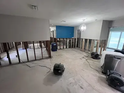Flood-cut walls and air movers drying an open living area in Plant City, FL