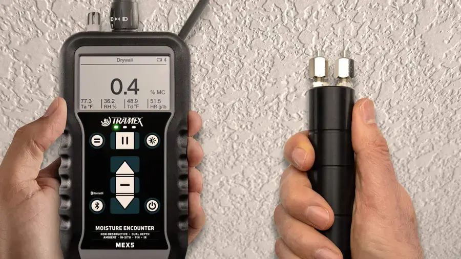 Pin and pinless moisture meters checking a textured wall for water damage